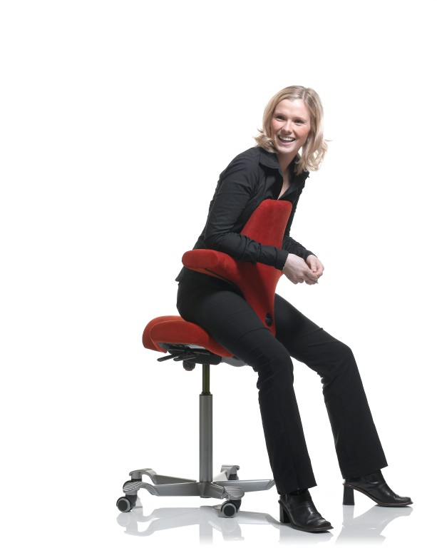 Sitting reversed on the Capisco 8106, chest against the backrest, casual pose
