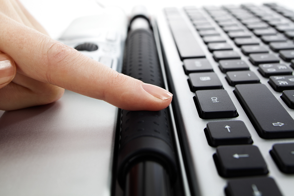 Close-up of a finger operating the rollerbar in front of a keyboard