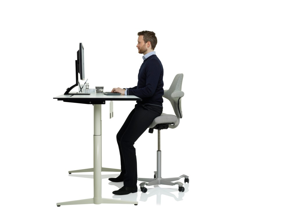 Sitting forward at a keyboard in the Capisco 8106, upright posture